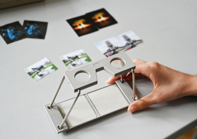 öffnet Foto mit einem Stereoskop, mit dem man dreidimensional sehen kann. 