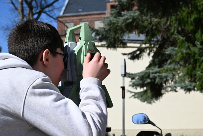 öffnet Bild mit einem Jungen beim Messen mit einem Tachymeter