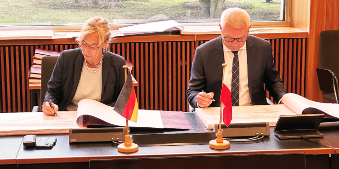 Die Vorsitzenden der deutschen und polnischen Grenzkommission, Frau Dr. Anna Deutelmoser, Ministerialrätin im Bundesministerium des Innern, sowie Oberst Arkadiusz Tywonuik vom polnischen Grenzschutz unterzeichnen das Grenzurkundenwerk.